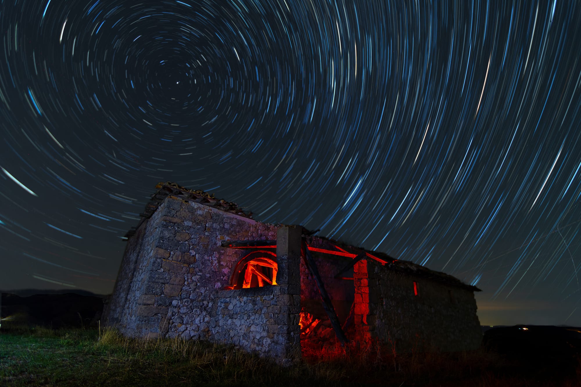 Estelas de estrellas girando en torno al polo celeste sobre un antiguo chozo de piedra en la estepa soriana